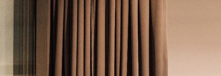 Brauner Vorhang vor beiger Wand